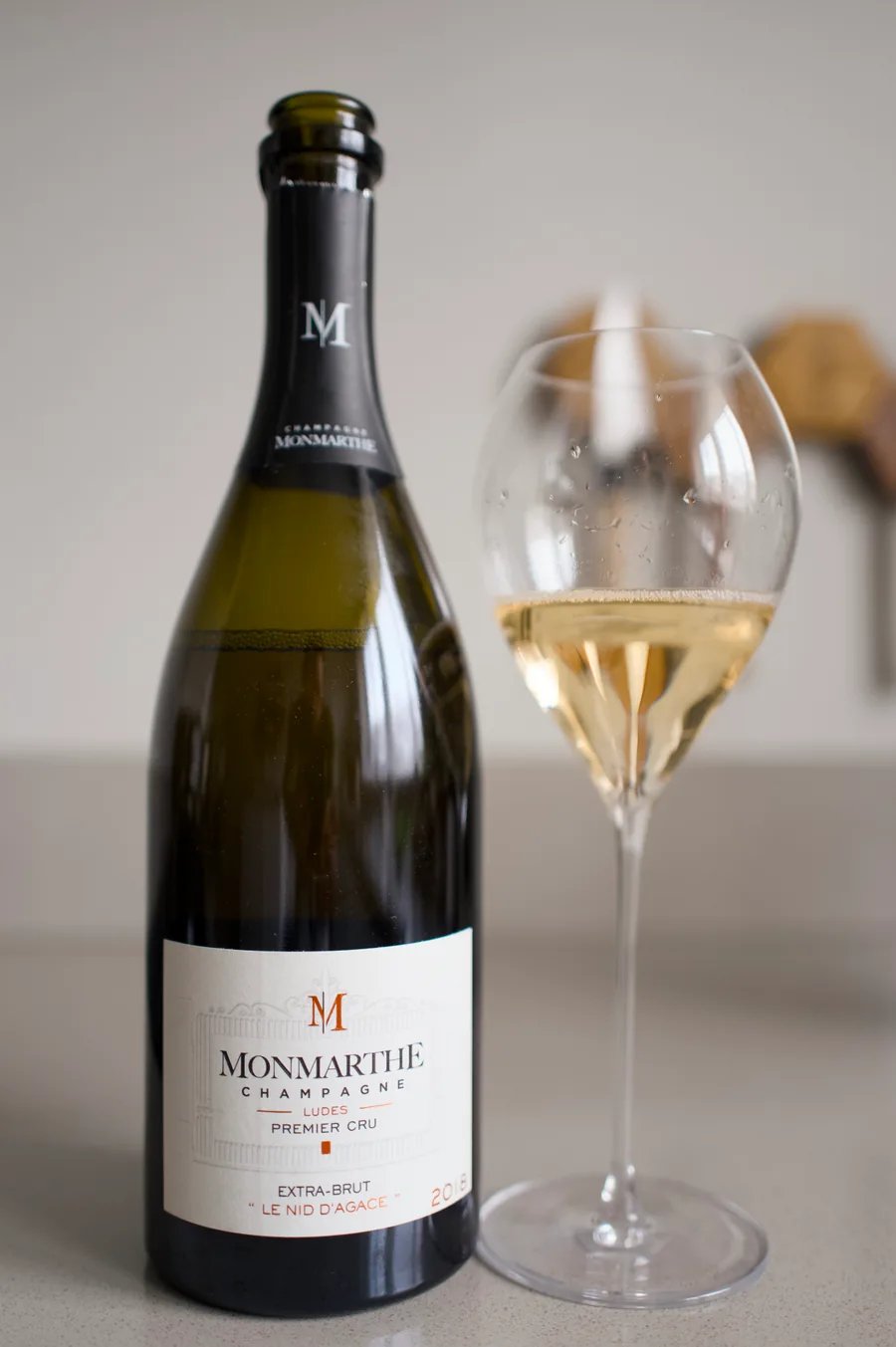 Bottle of Champagne Monmarthe Le Nid d'Agace Extra Brut with a glass