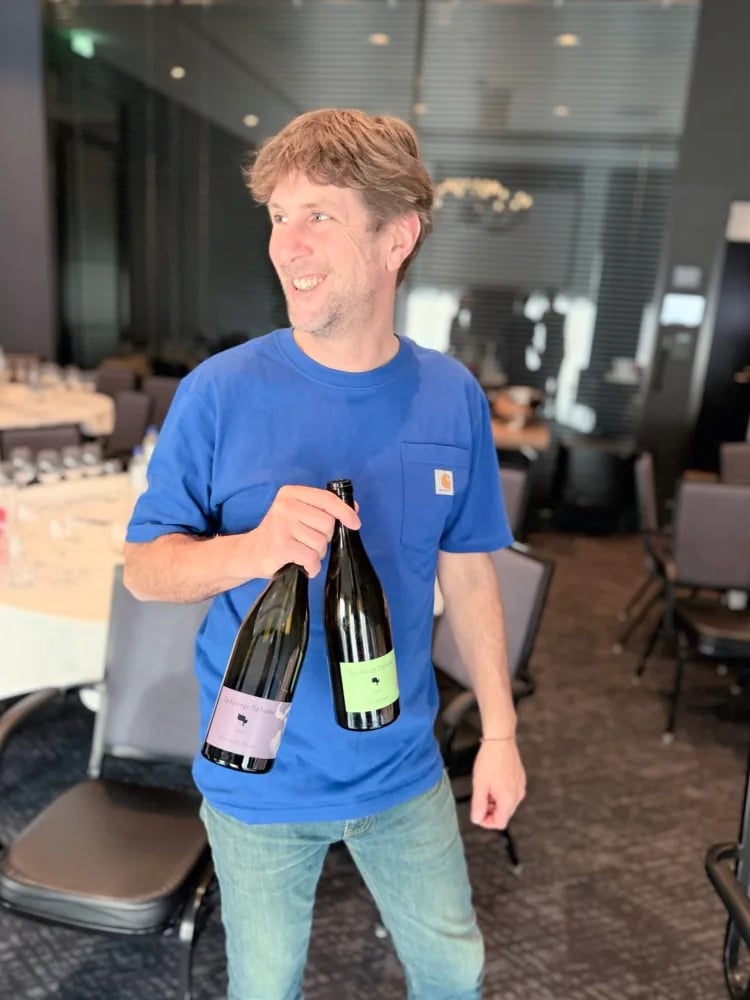 Damien Delecheneau holding two La Grange Tiphaine bottles