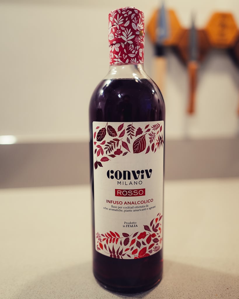 Conviv Milano Rosso bottle with a red leaf label next to an empty tumbler