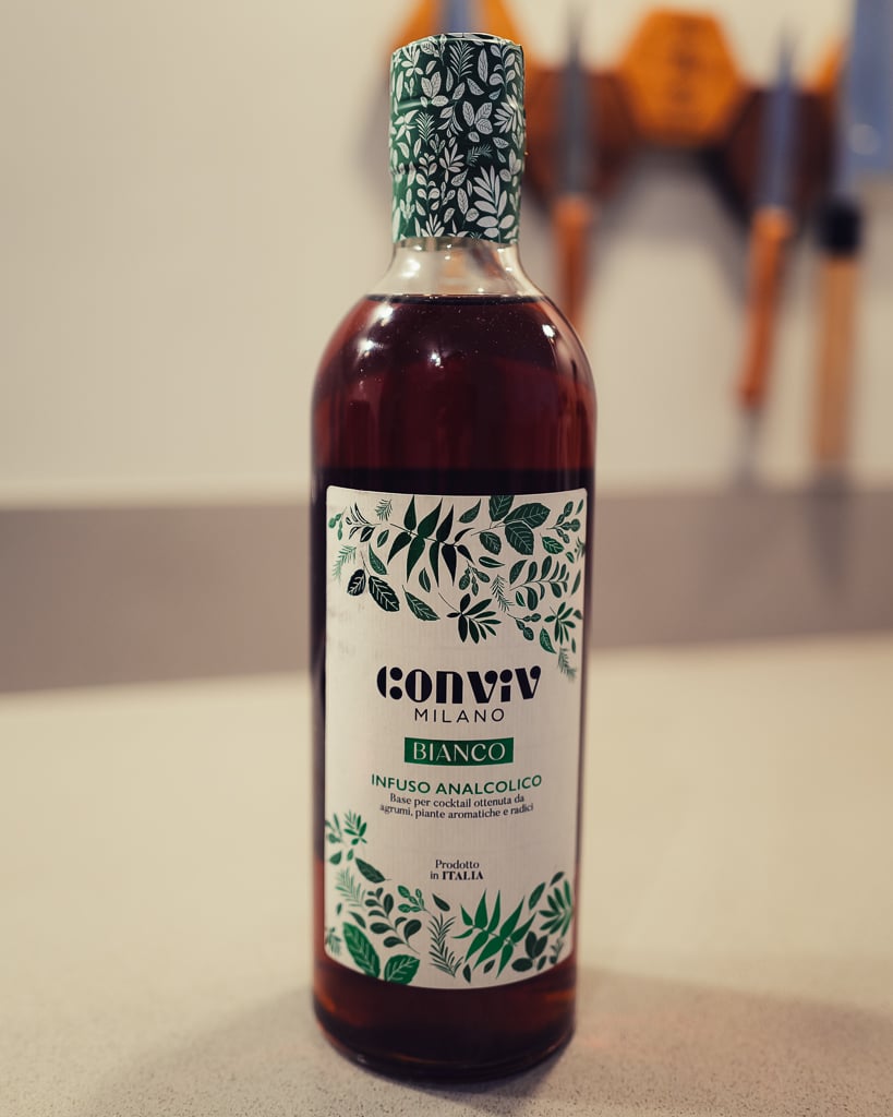 Conviv Milano Bianco bottle with a leafy green label and cap standing on a counter