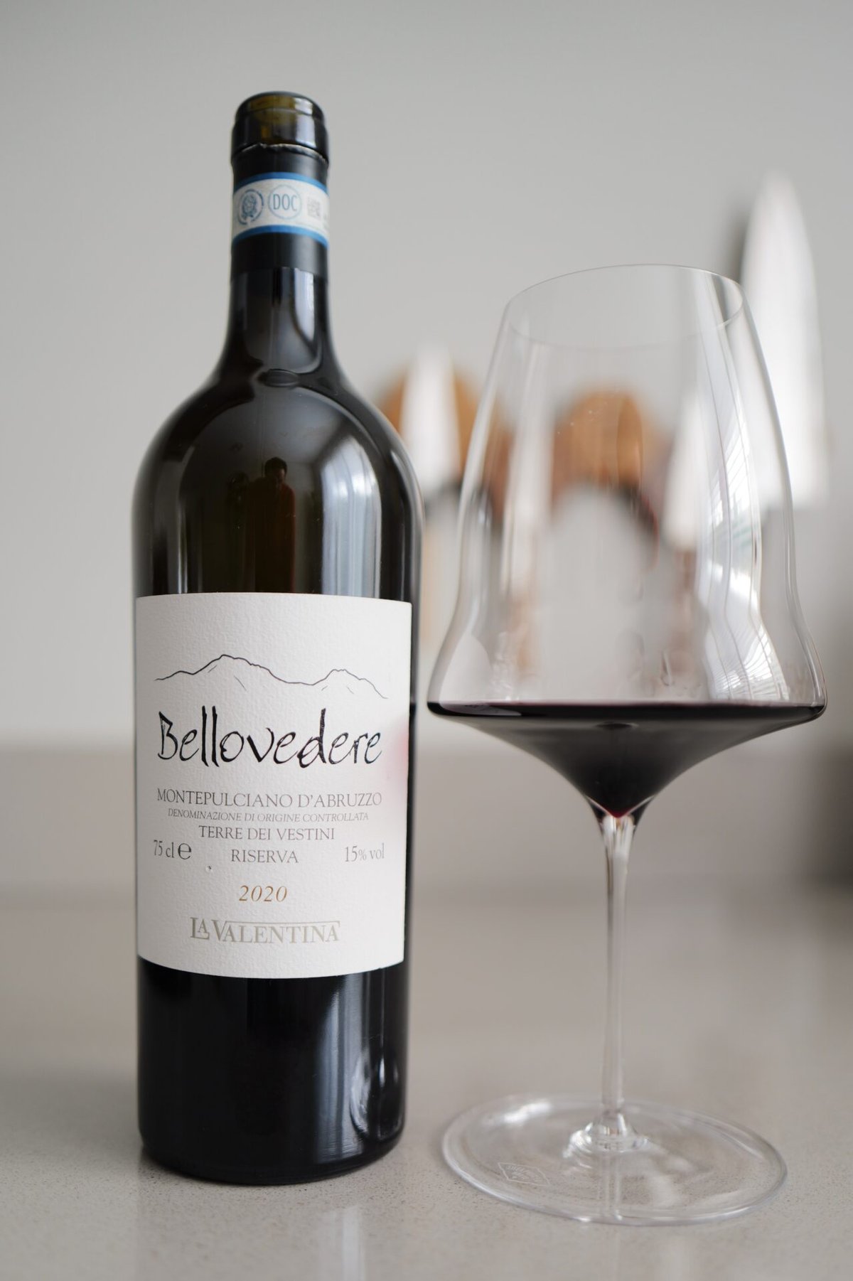 Bellovedere 2020 Montepulciano d'Abruzzo bottle beside a glass of deep red wine