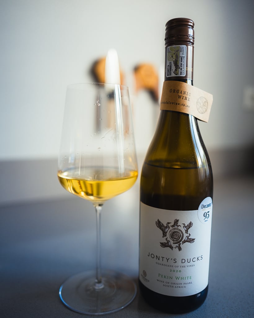 Jonty's Ducks Pekin White 2021 bottle next to a glass of golden white wine
