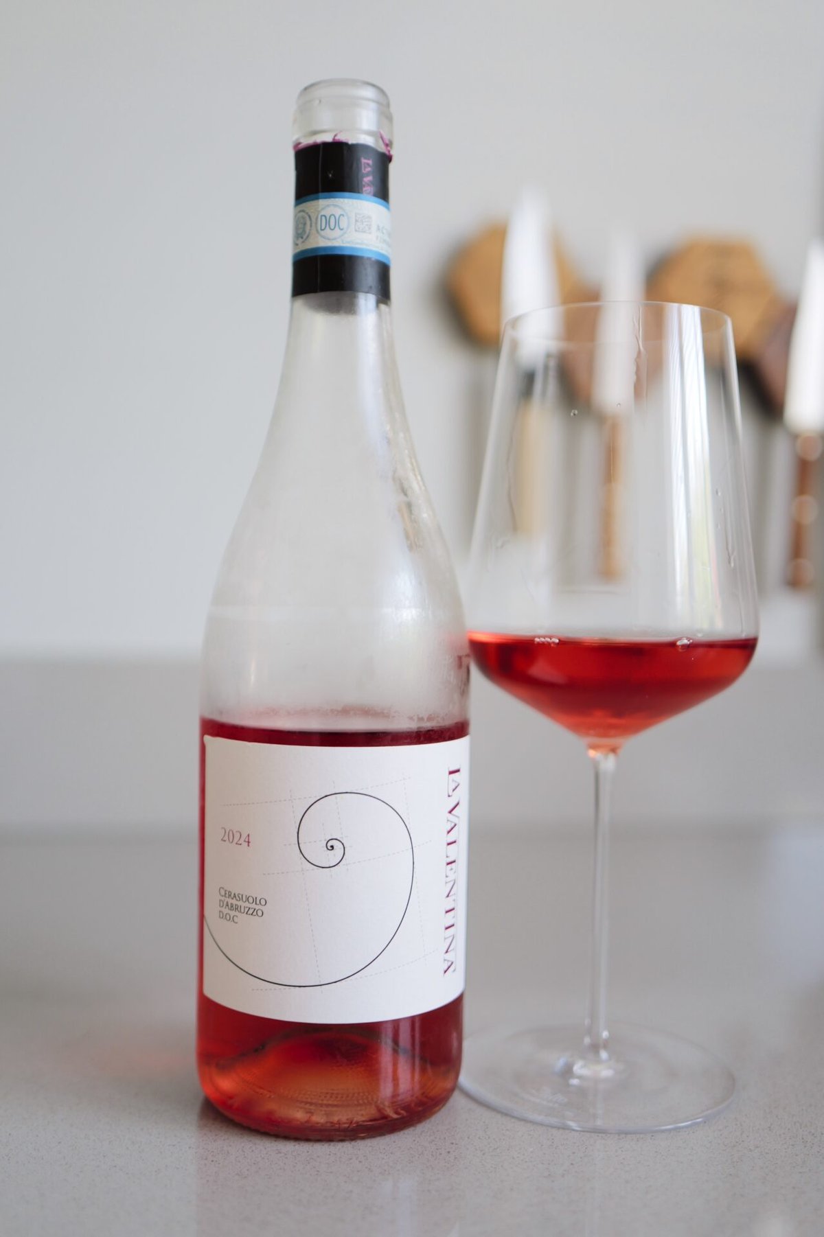 La Valentina Cerasuolo d'Abruzzo 2024 bottle with spiral label beside a glass of cherry-pink rosé