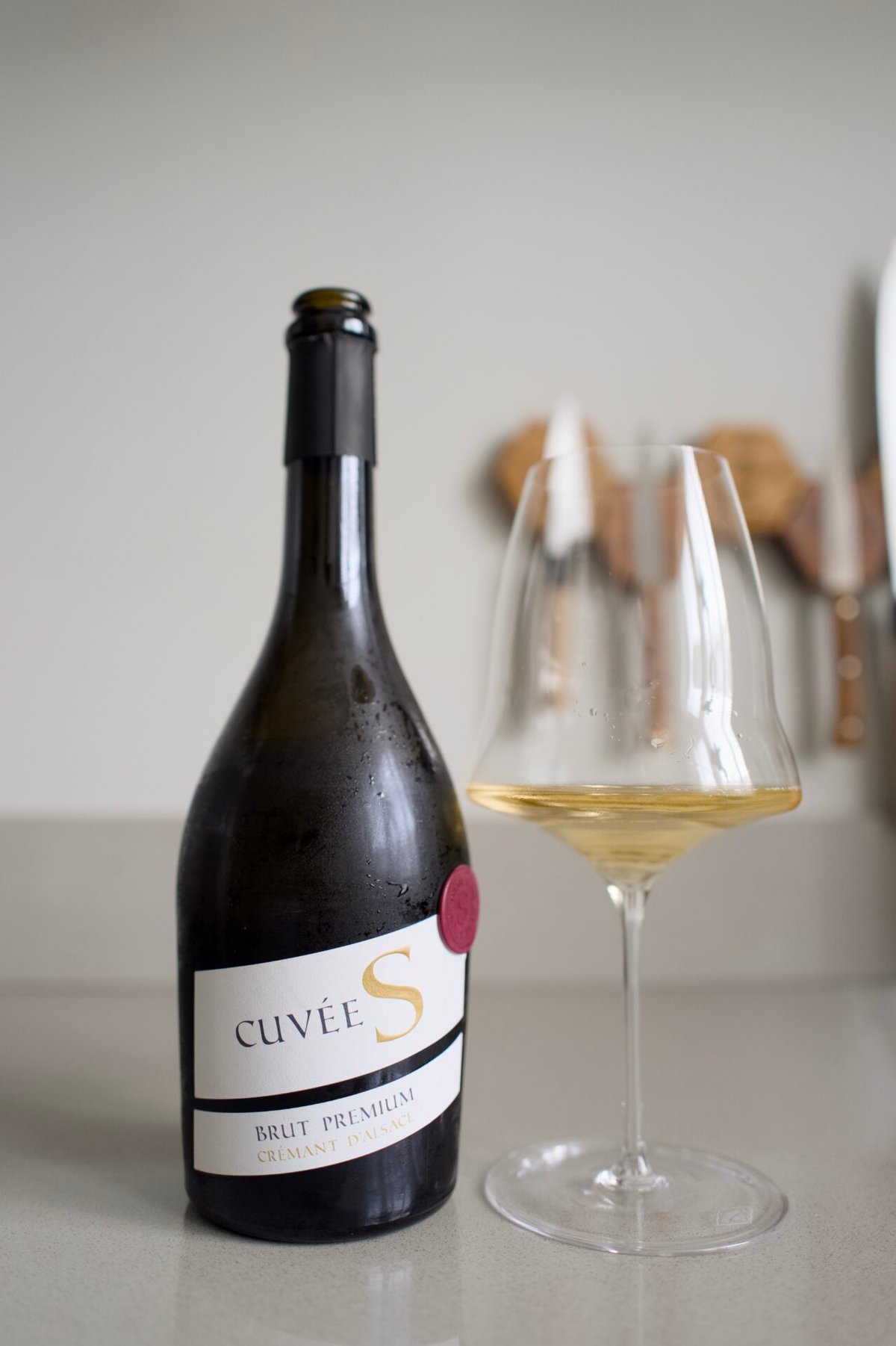 Cuvée S Brut Premium Crémant d'Alsace bottle beside a glass of sparkling wine