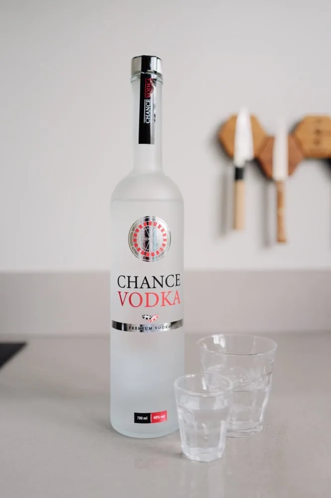 Chance Vodka bottle with roulette-wheel label next to two glasses on the counter