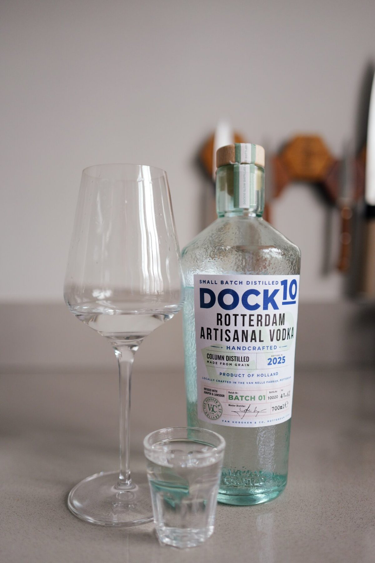 DOCK10 Rotterdam Vodka bottle with a tall wine glass and a filled shot glass on a counter