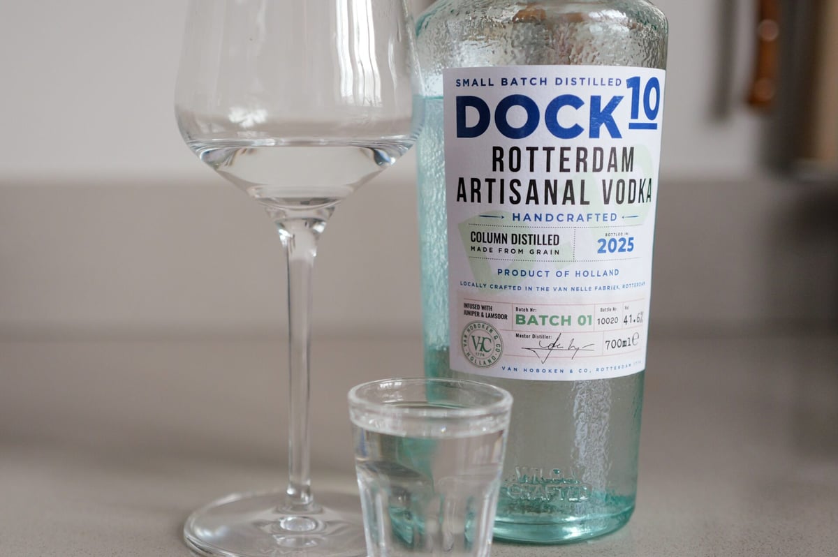 Close-up of the DOCK10 Rotterdam Vodka label beside a wine glass and a shot of clear vodka