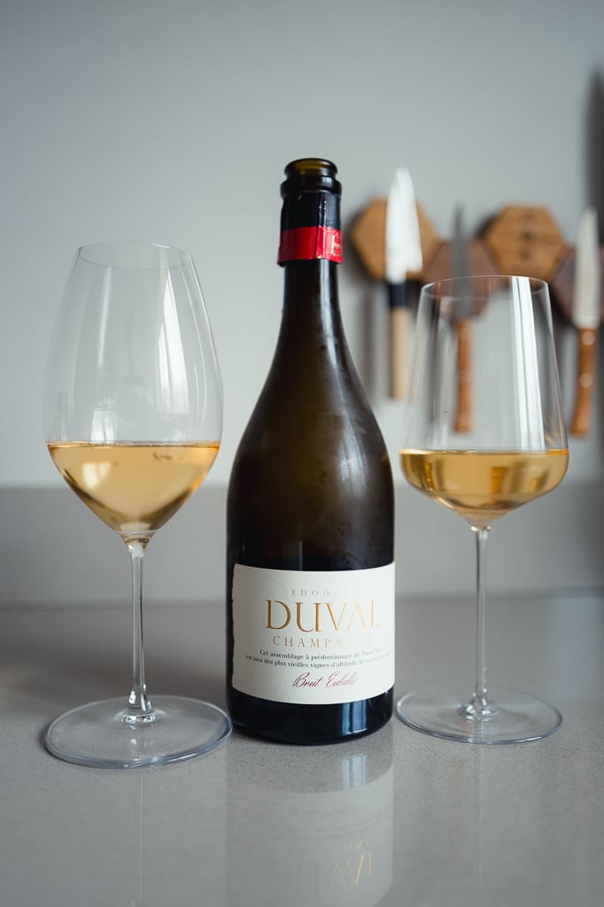 Edouard Duval Brut Eulalie bottle between two glasses of pale golden champagne on a counter