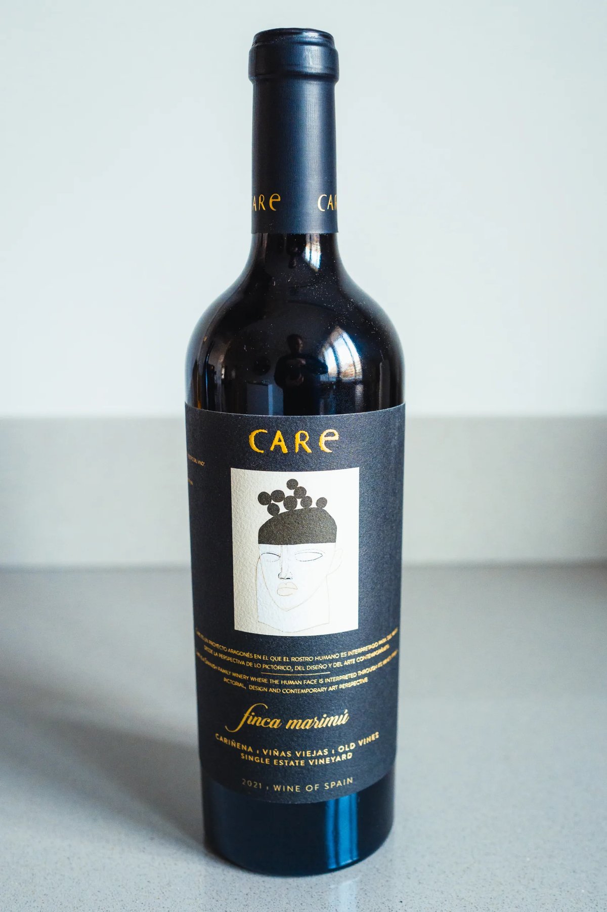 Bodegas Care Finca Marimú red wine bottle with a black label showing a stylised face