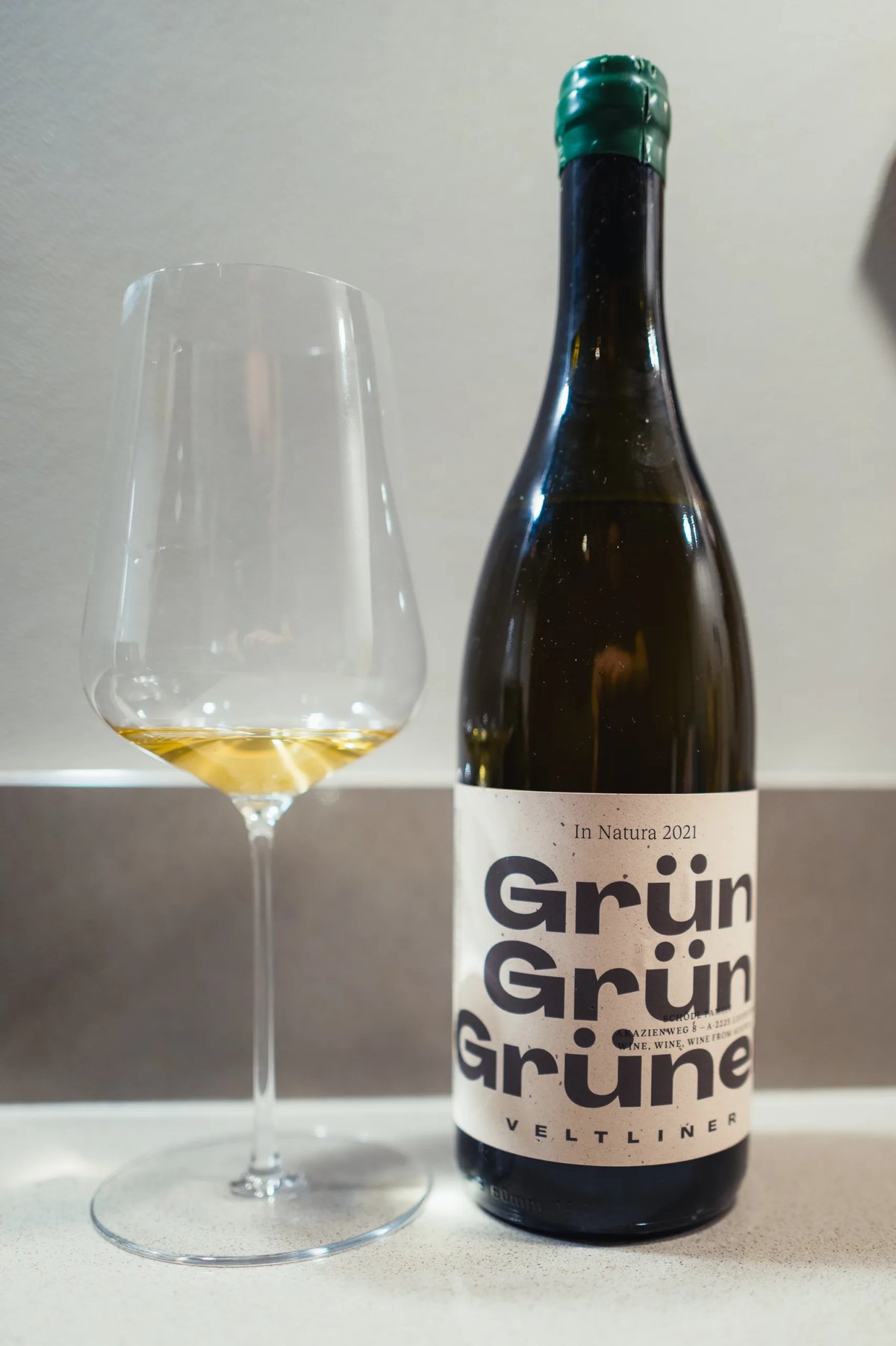 Schödl Grün Grün Grüner Veltliner In Natura bottle beside a glass of white wine