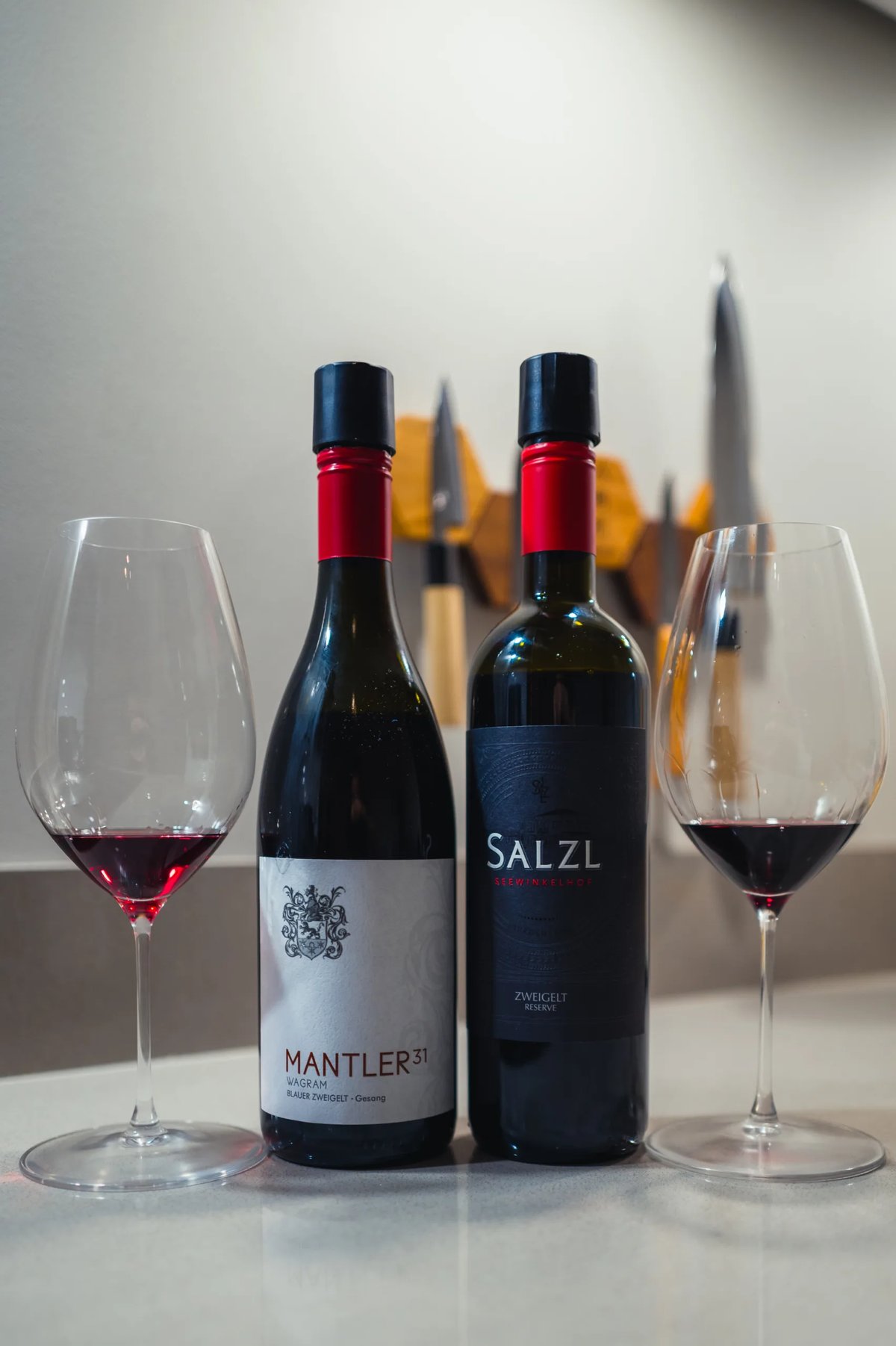 Mantler 31 Zweigelt and Salzl Zweigelt Reserve red bottles between two glasses of red wine