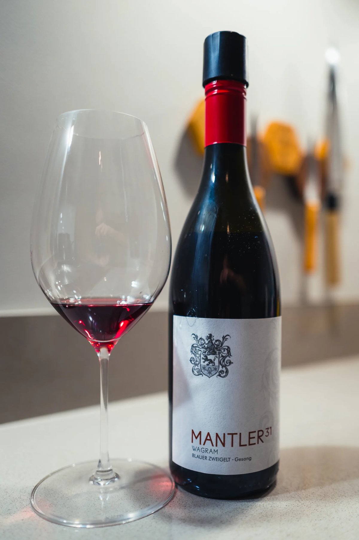 Mantler 31 Blauer Zweigelt red bottle beside a glass of red wine