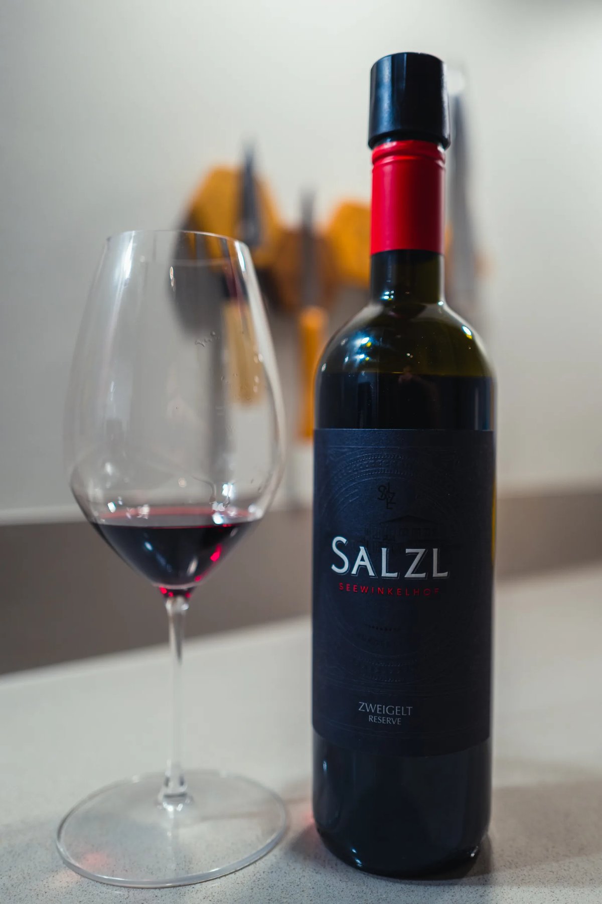 Salzl Zweigelt Reserve dark bottle beside a glass of deep red wine