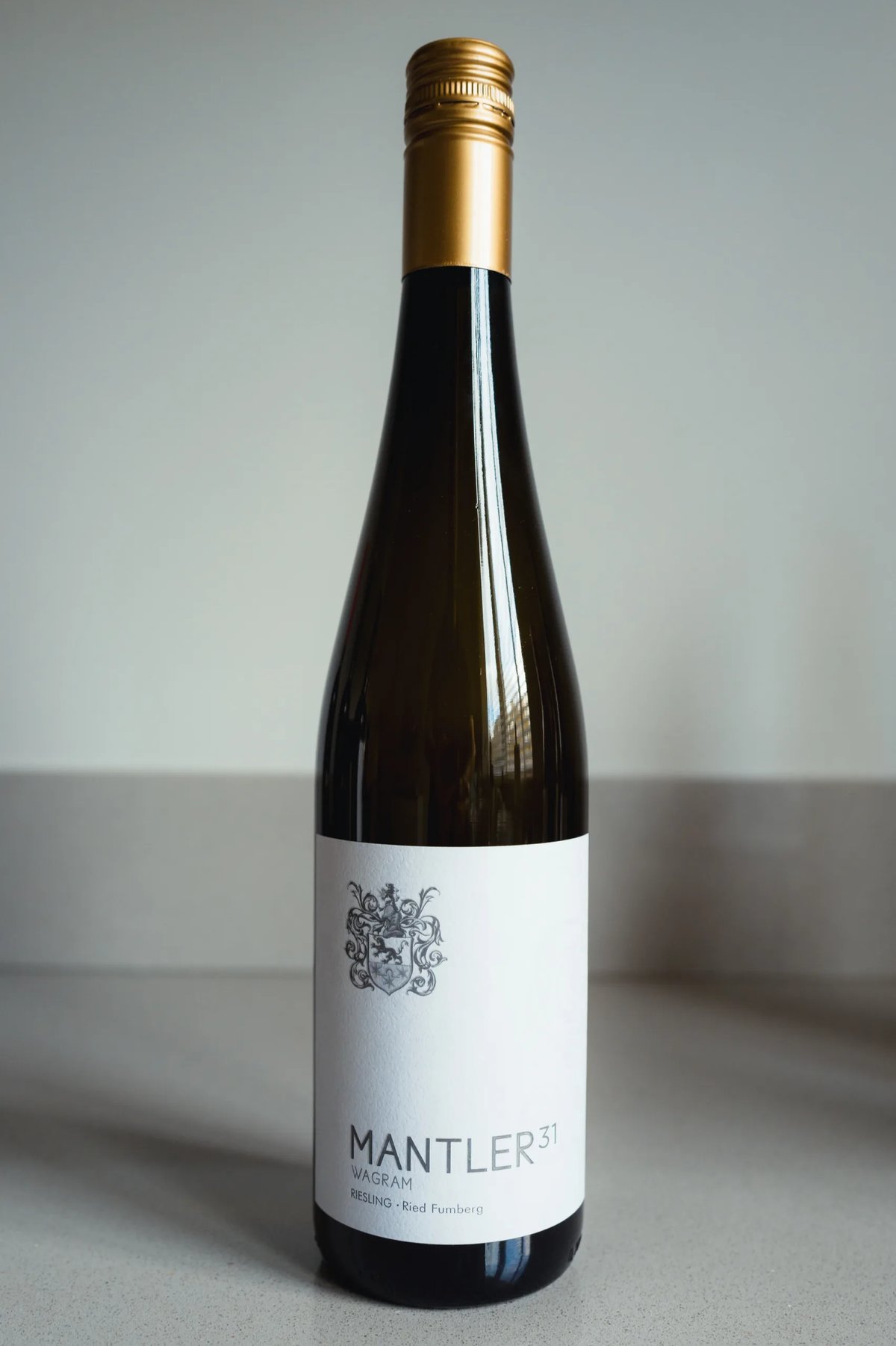 Mantler 31 Riesling Ried Fumberg bottle with gold foil standing on a counter