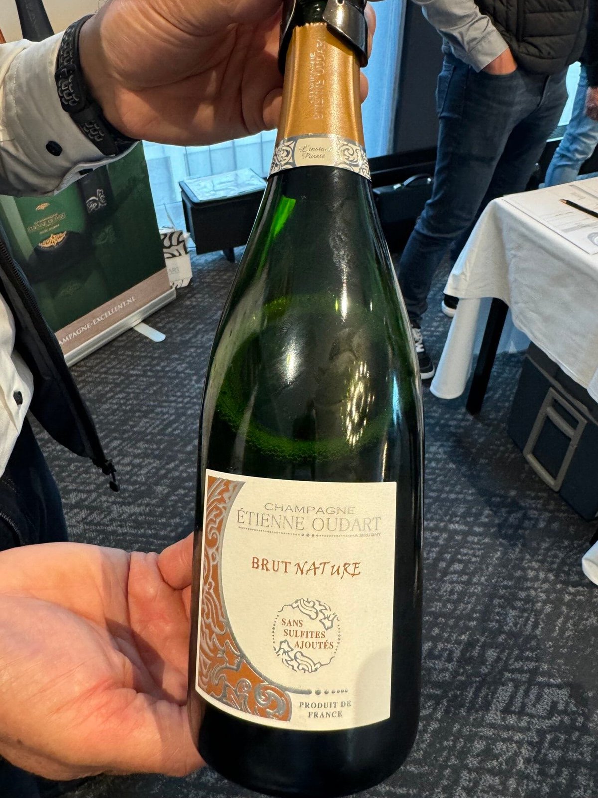 Hand holding a bottle of Champagne Étienne Oudart Brut Nature, Sans Sulfites Ajoutés