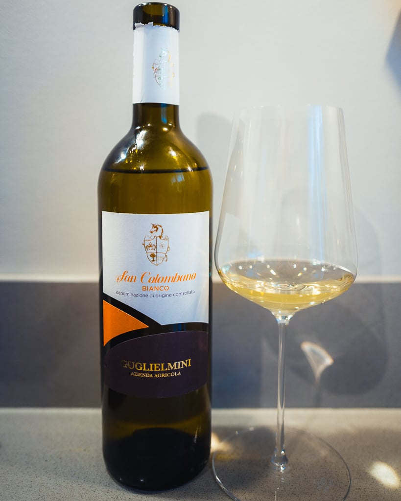 Guglielmini San Colombano Bianco bottle with cream label beside a glass of white wine