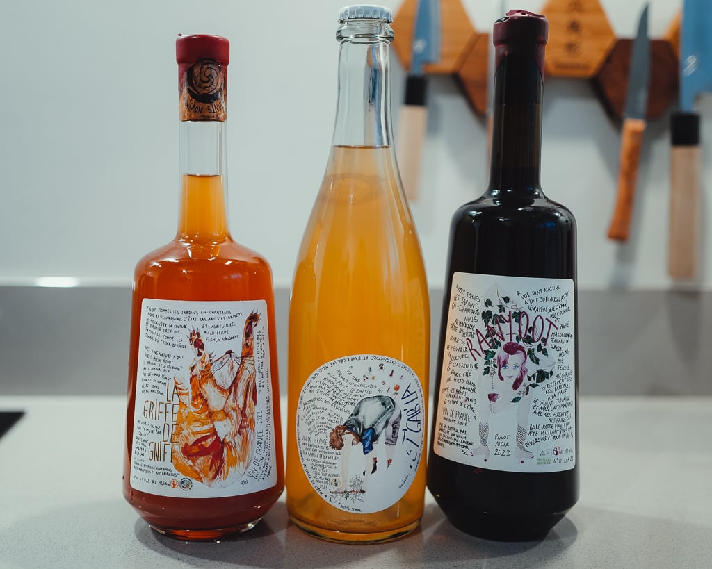 Three Les Jardins En-Chantants bottles in a row: orange wine, cloudy pet-nat and dark red