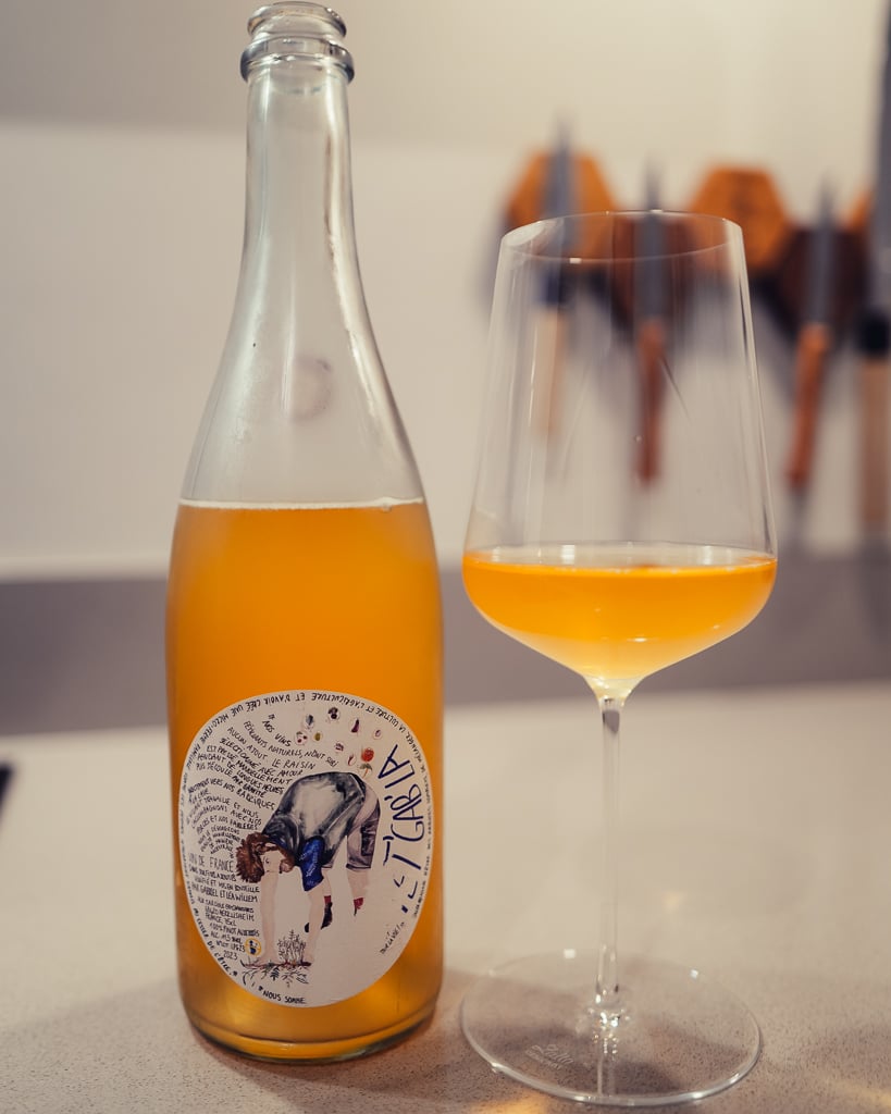 La Griffe de Gniff orange wine bottle with cat illustration beside a glass of amber wine