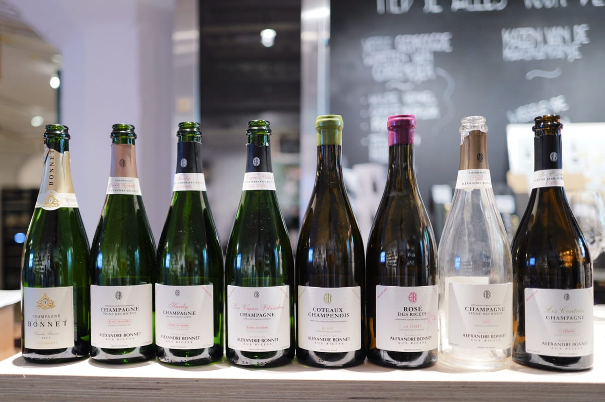 Eight Alexandre Bonnet Champagne bottles lined up on a wooden counter