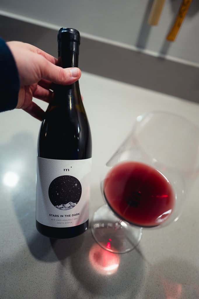 Minimalist Wines Stars in the Dark bottle held beside a glass of red wine