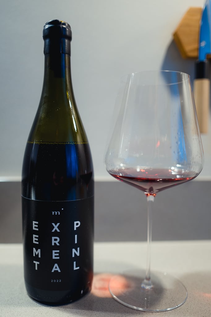 Minimalist Wines Experimental bottle standing beside a glass of red wine