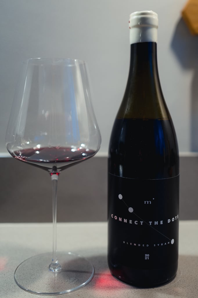 Minimalist Wines Connect the Dots bottle standing beside a glass of red wine