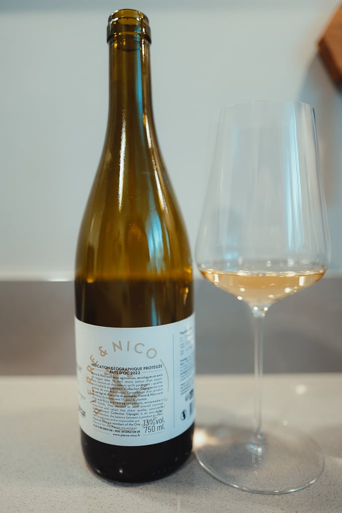Pierre & Nico organic wine bottle shown back-label first beside a glass of white wine