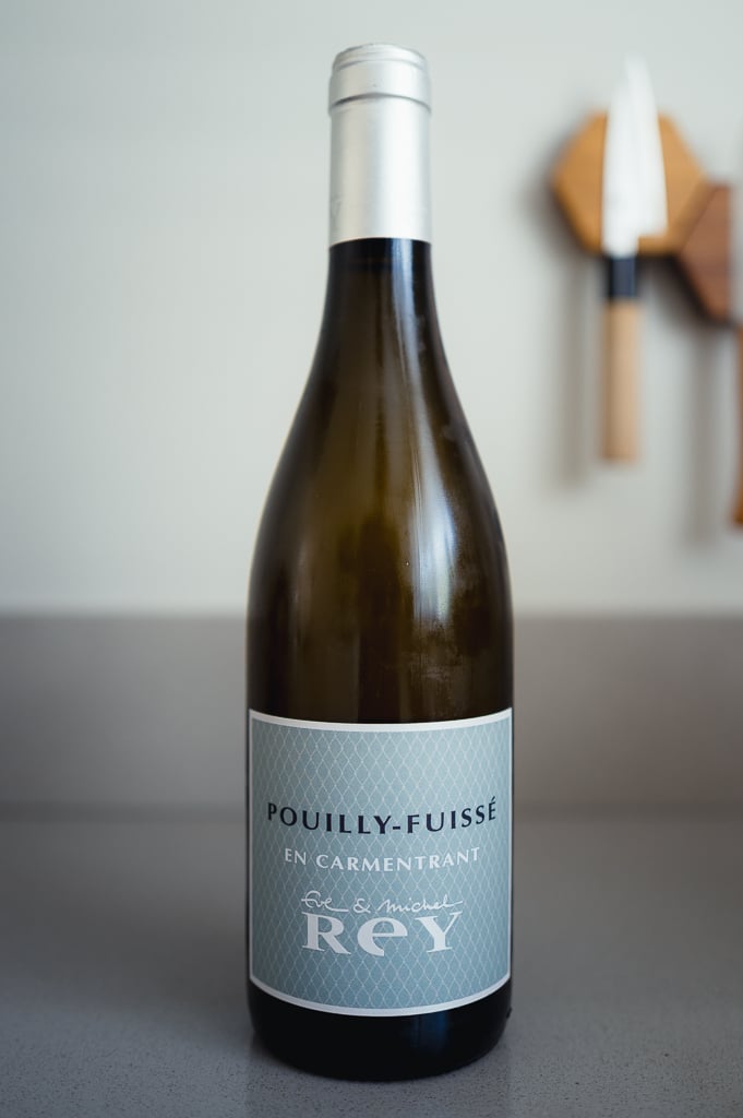 Bottle of Pouilly-Fuissé En Carmentrant by Eve & Michel Rey on a grey table