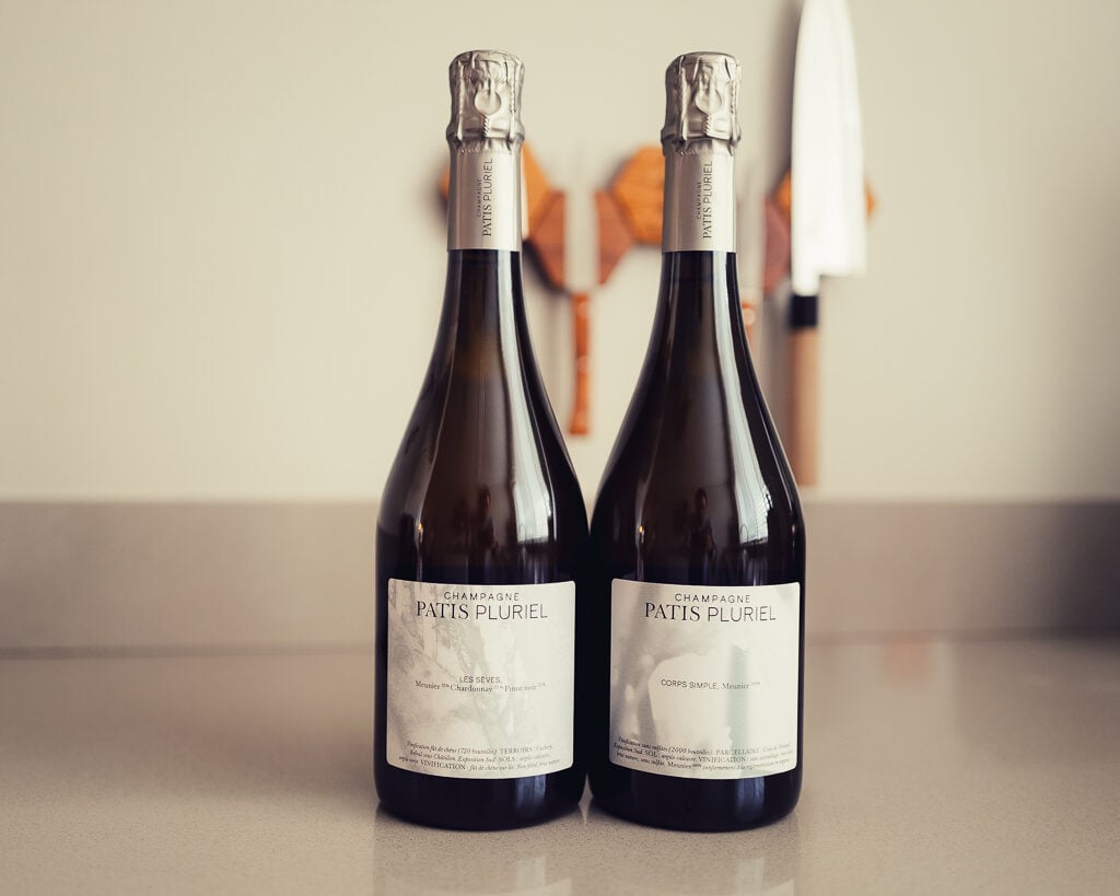Two Patis Pluriel champagne bottles standing side by side, Les Sèves and Corps Simple