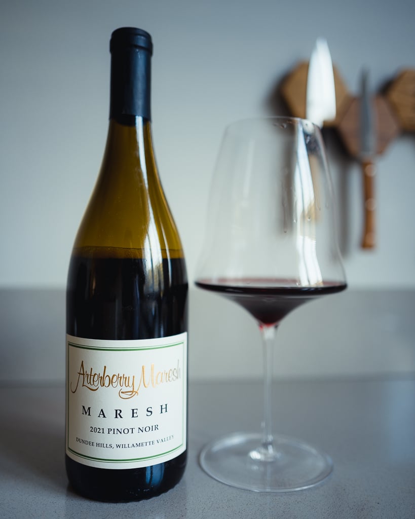 Arterberry Maresh 2021 Pinot Noir bottle beside a glass with red wine residue on a counter