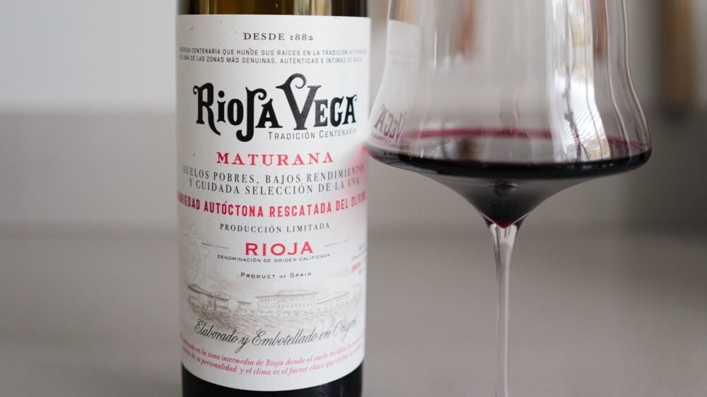 Close-up of the Rioja Vega Maturana front label beside a glass of dark red wine