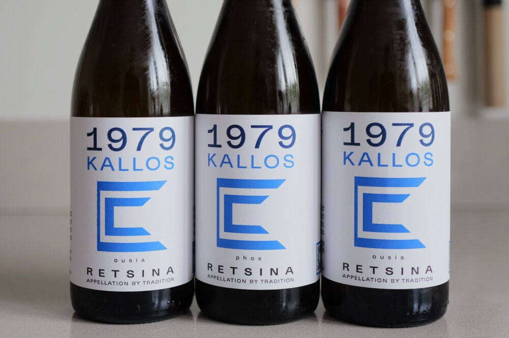 Three 1979 Kallos Retsina bottles in a row with blue and white geometric labels