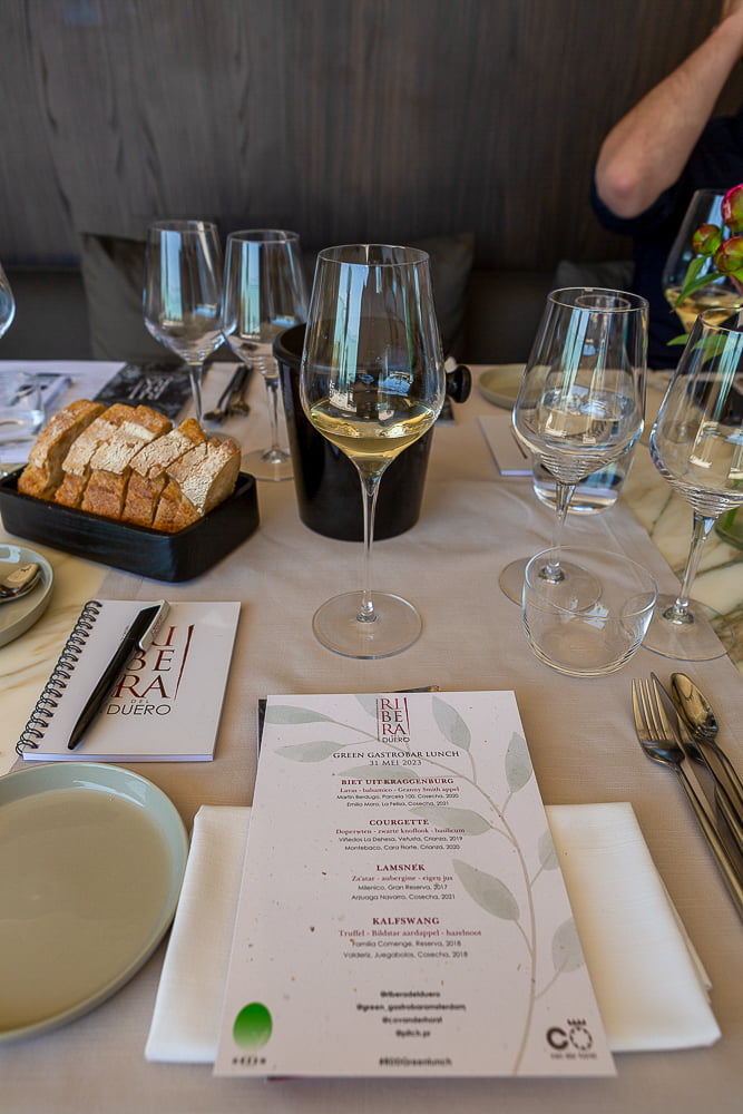 Set tasting table with a Ribera del Duero menu, wine glasses, bread and a bottle cooler