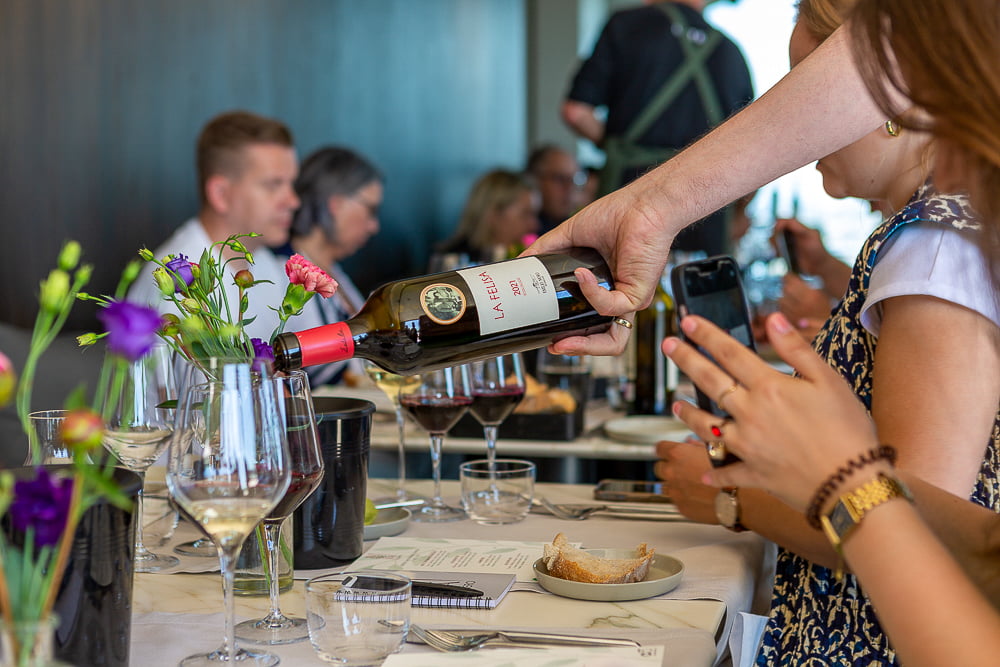 Bottle of La Felisa 2021 Ribera del Duero held over the table as a guest photographs it