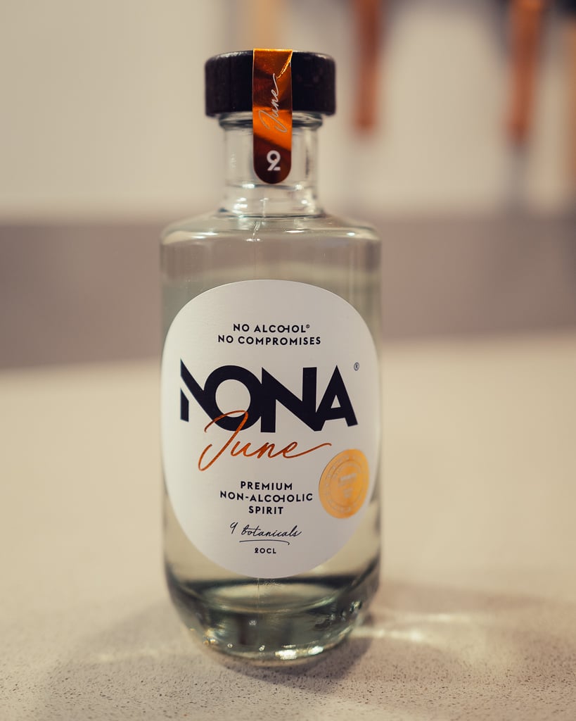 Close-up of the clear NONA June non-alcoholic spirit bottle with its white label