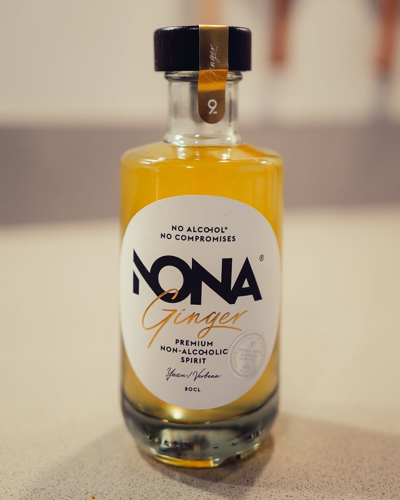 Close-up of the NONA Ginger non-alcoholic spirit bottle with cloudy yellow liquid