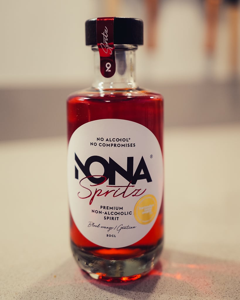 Close-up of the NONA Spritz non-alcoholic spirit bottle filled with deep red liquid