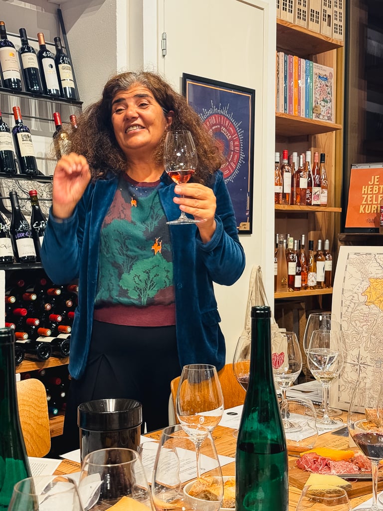 Carmen raising a glass of amber-hued white wine during the masterclass