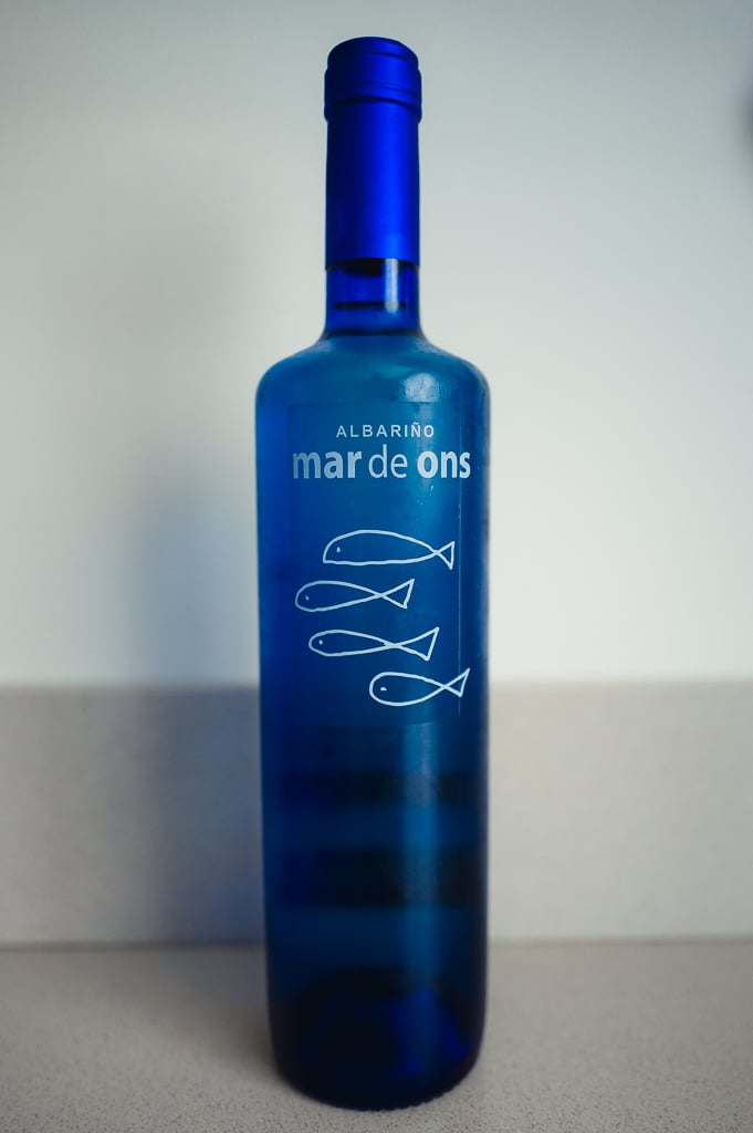 Cobalt blue Mar de Ons Albariño bottle with white fish illustrations on the label