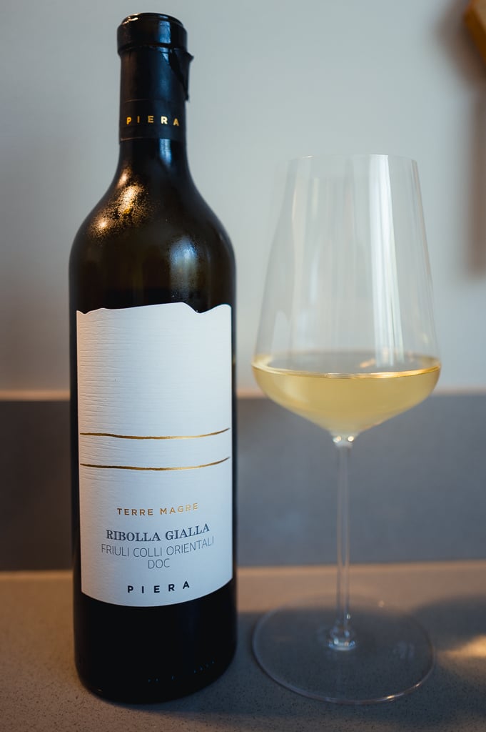 Piera Terre Magre Ribolla Gialla bottle standing beside a glass of pale white wine
