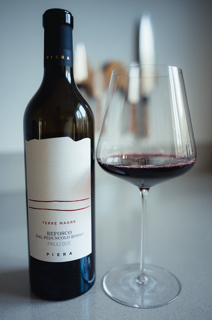 Piera Refosco dal Peduncolo Rosso bottle beside a glass of deep red wine