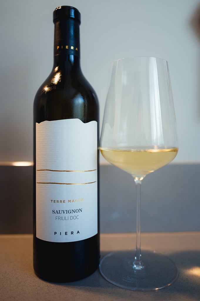 Piera Terre Magre Sauvignon bottle standing next to a glass of golden white wine