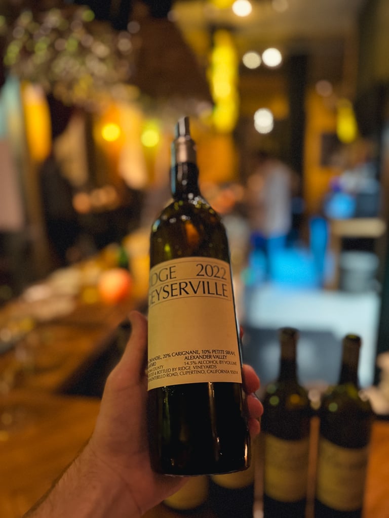 Hand holding the Ridge Geyserville 2022 Alexander Valley bottle in the wine bar