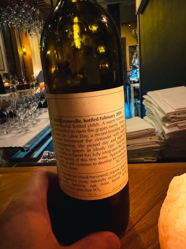 Back label of the Ridge Geyserville 2022 bottle on a table by a salt lamp