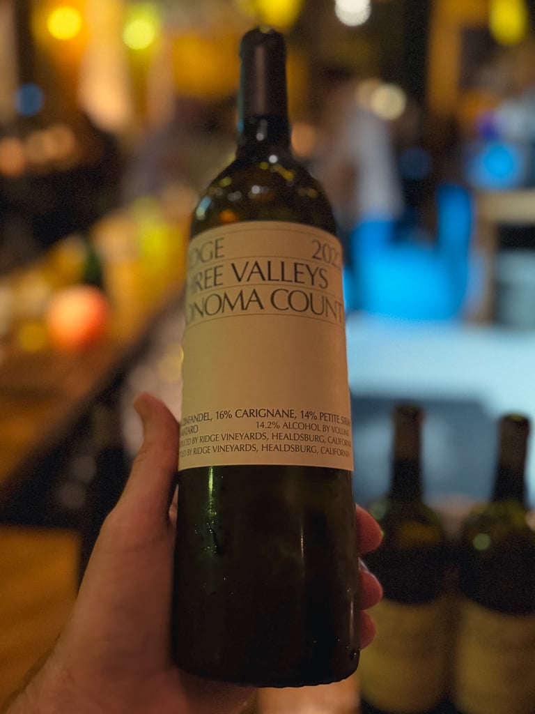 Hand holding the Ridge Three Valleys Sonoma County bottle in the wine bar