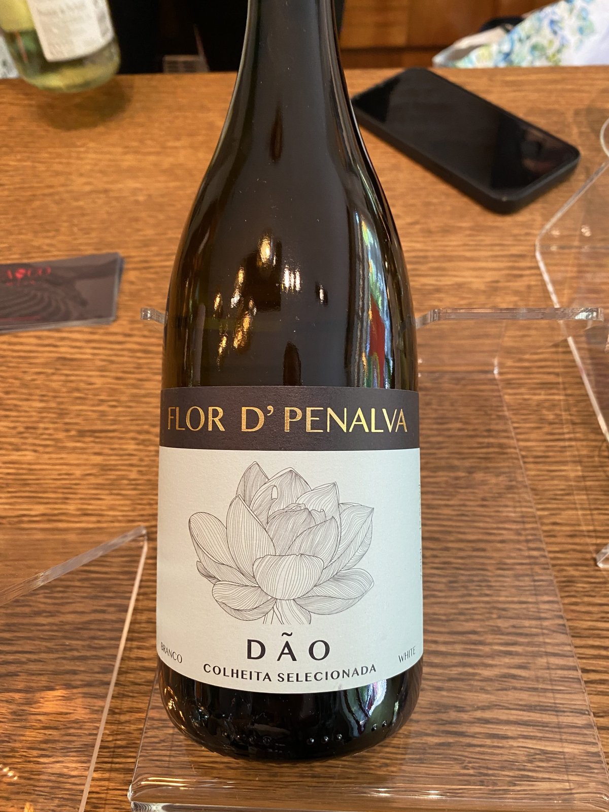 Flor d'Penalva Dao white wine bottle with a lotus flower label on a wooden table