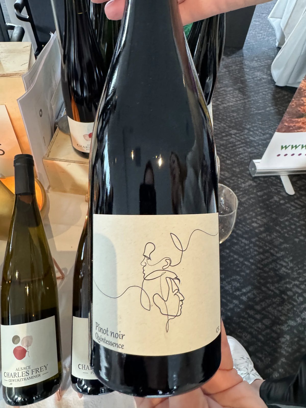 Charles Frey Pinot Noir Quintessence bottle with a line-drawn face label, beside a Gewurztraminer bottle