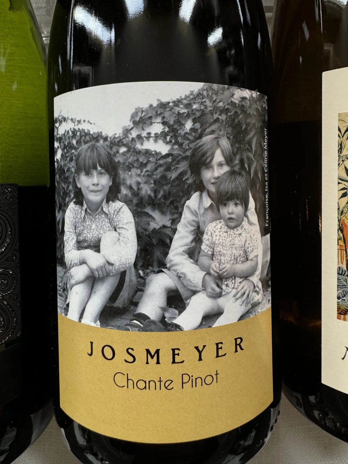 Josmeyer Chante Pinot bottle with a black-and-white photo label of three children, between two other bottles