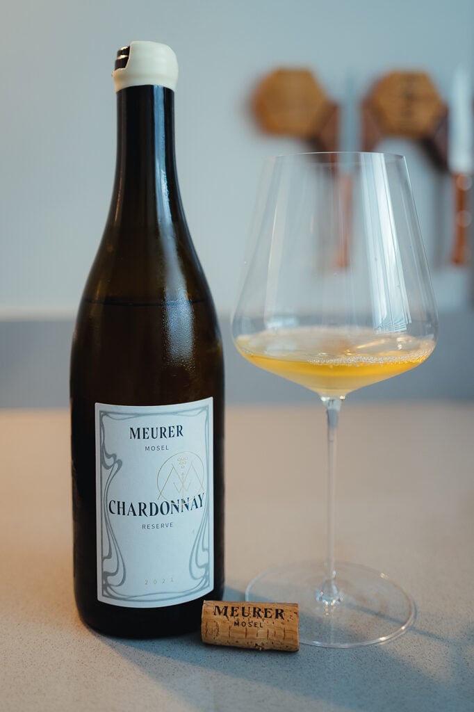 Meurer Chardonnay Reserve bottle with a wax-dipped top and white label, beside a glass of wine and a branded cork