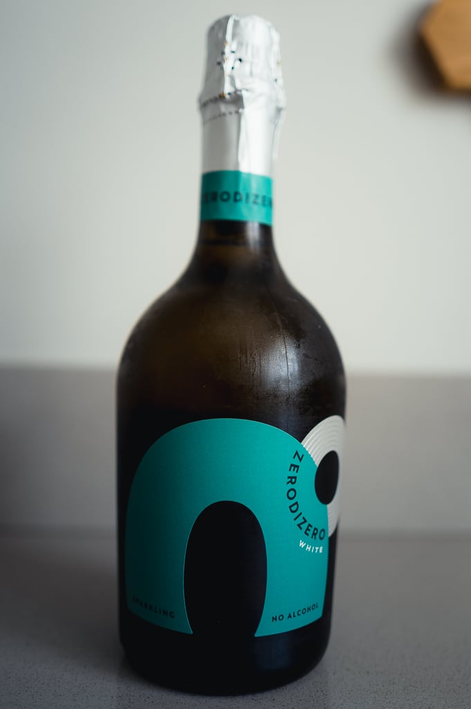 ZeroDiZero White no-alcohol sparkling bottle with a teal label and foil top, standing on a counter
